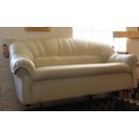 A two seater settee covered in cream faux leather