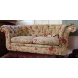 A two seater florally upholstered scrolled armed and button back settee