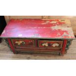 A Chinese low table with two drawers and red paint with floral decoration