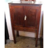 A 1920's bespoke oak cabinet with two doors standing on square champered legs