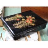 A black lacquered and gilded box in a wooden travelling case