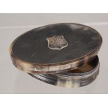 An oval horn snuff box with silver shield applied to lid