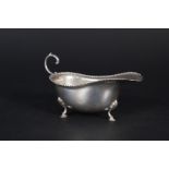 A Scottish silver Hamilton & Inches sauce boat with beaded edge on three hoof feet,