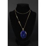 A large oval blue hard stone pendant mounted in 9ct gold on a 9ct gold chain