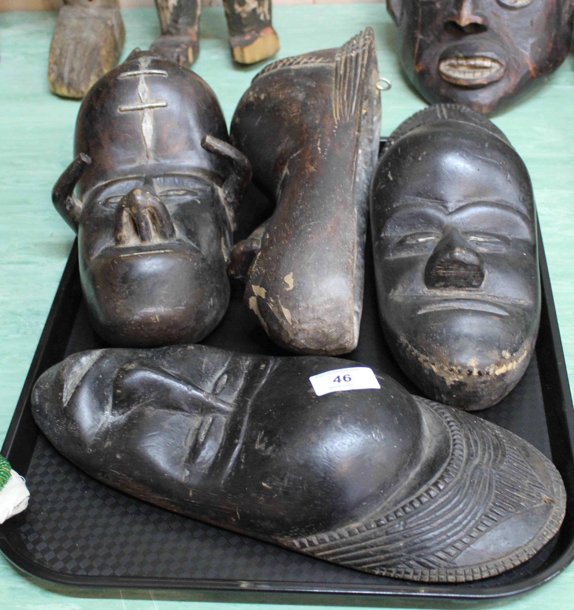 Four West African wall masks with aluminium inlay,