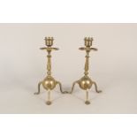 A pair of Arts and Crafts brass candlesticks in the manner of W.A.S.