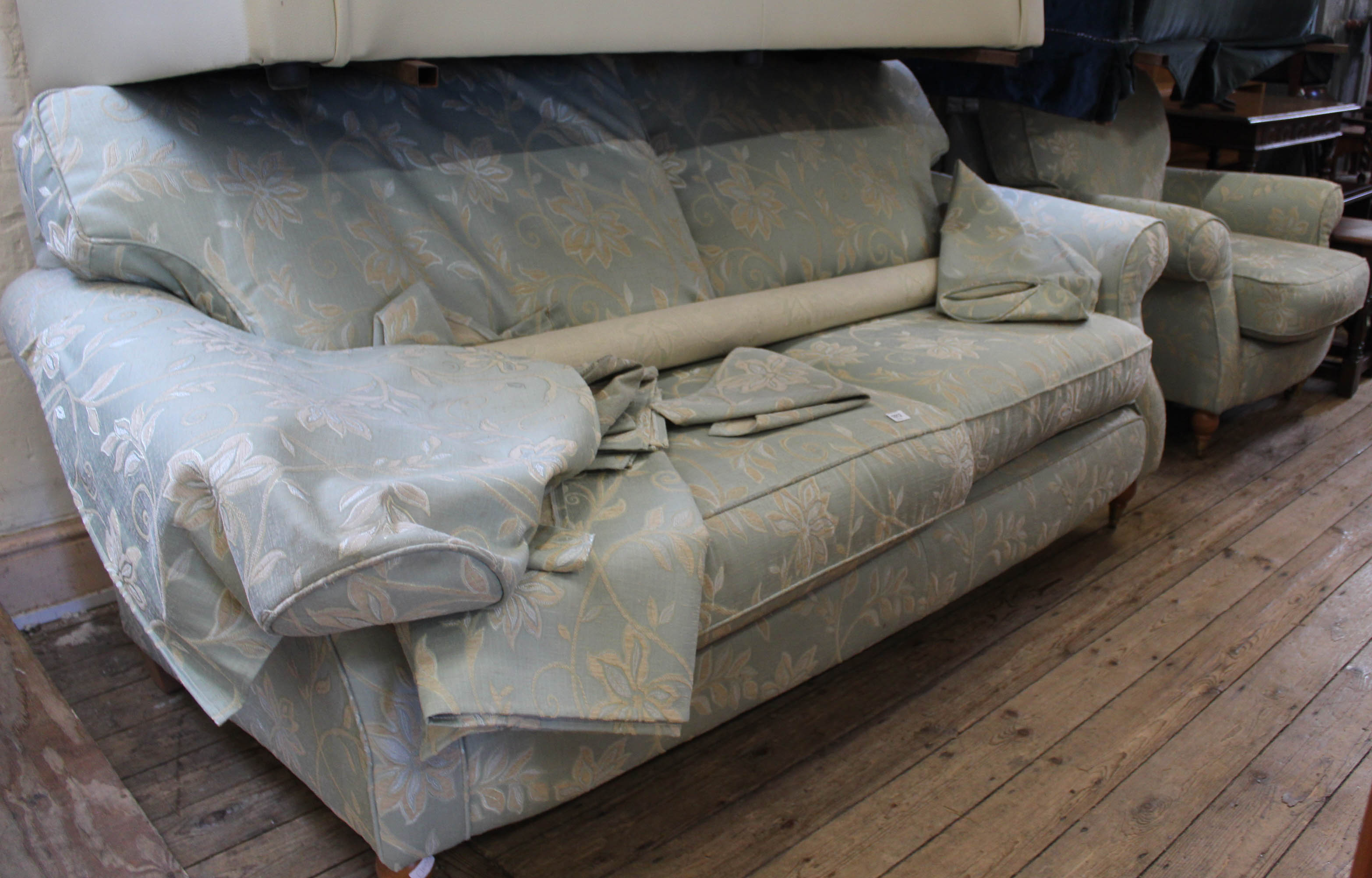 A three seater pale green and cream upholstered sofa with matching armchair