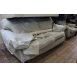 A three seater pale green and cream upholstered sofa with matching armchair