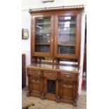 A substantial Edwardian American walnut cupboard bookcase with adjustable shelves and glazed