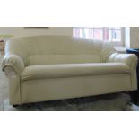A two seater settee covered in cream faux leather