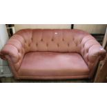 A two seater Chesterfield sofa upholstered in dusky pink draylon