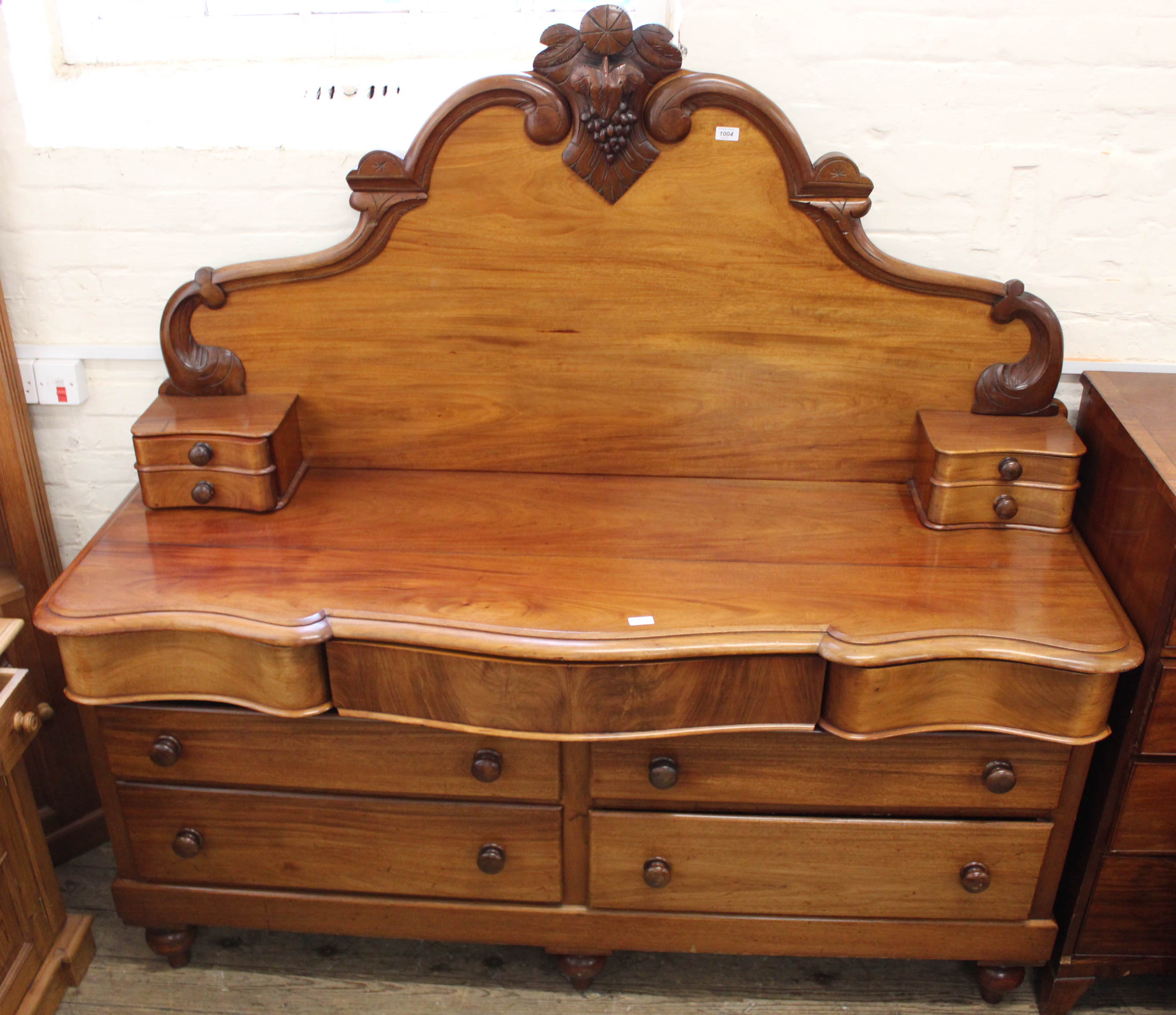 A mid Victorian mahogany eleven drawer sideboard with carved mahogany upstand