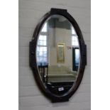 A carved oak oval bevelled mirror