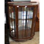 A 1950's bow front glazed display cabinet with glass shelves
