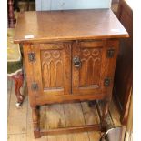 A mid 20th Century oak two door cupboard with stretcher base
