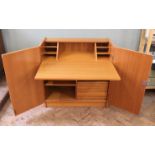 A 1970's teak cabinet which converts into a desk