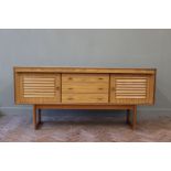 A vintage sideboard with three drawers and two slatted door cupboards