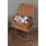 A folding picnic table and hamper with picnic contents