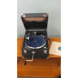 A portable wind up gramophone record player with 78's