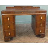 A 1930's oak six drawer desk with Art Deco handles and carving to front