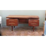 A 1970's teak G Plan desk with floating top