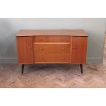 A 1960's sideboard with three drawers flanked by two cupboard doors on black painted legs