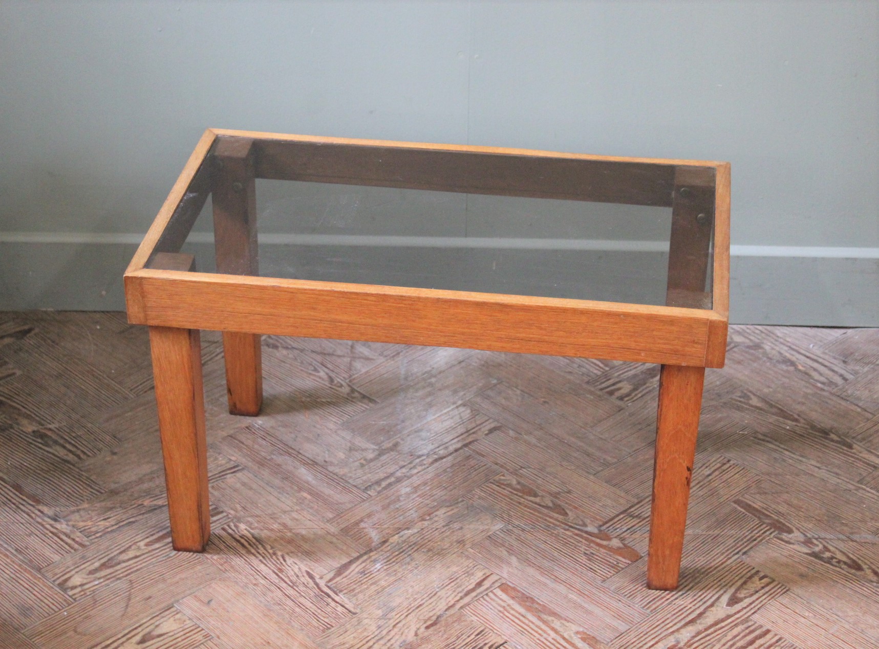 A small teak effect and smoked glass occasional table on tapered legs