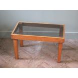 A small teak effect and smoked glass occasional table on tapered legs