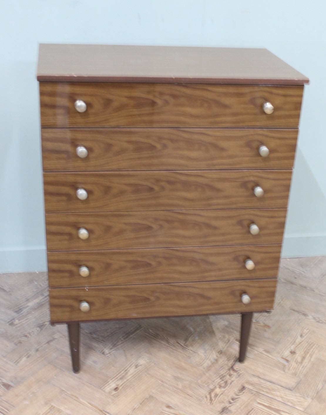 A 1960's Schreiber chest of six long drawers on tapered legs