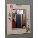 A florally painted bedroom mirror with jewellery hooks