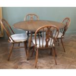 An Ercol flap leaf dining table and four chairs
