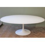 A large white oval tulip table on cast metal base