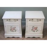 A pair of white painted bedside cabinets decorated with flowers