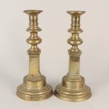 A pair of late 18th Century Adam style brass candlesticks on square bases,