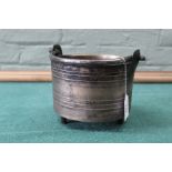 A 17th/18th Century bronze tripod cauldron with Founders mark and iron swing handle,