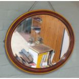 An oval bevel edged mirror with inlaid frame,