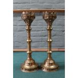A pair of large Gothic style brass pricket candlesticks with floral and beaded decoration on