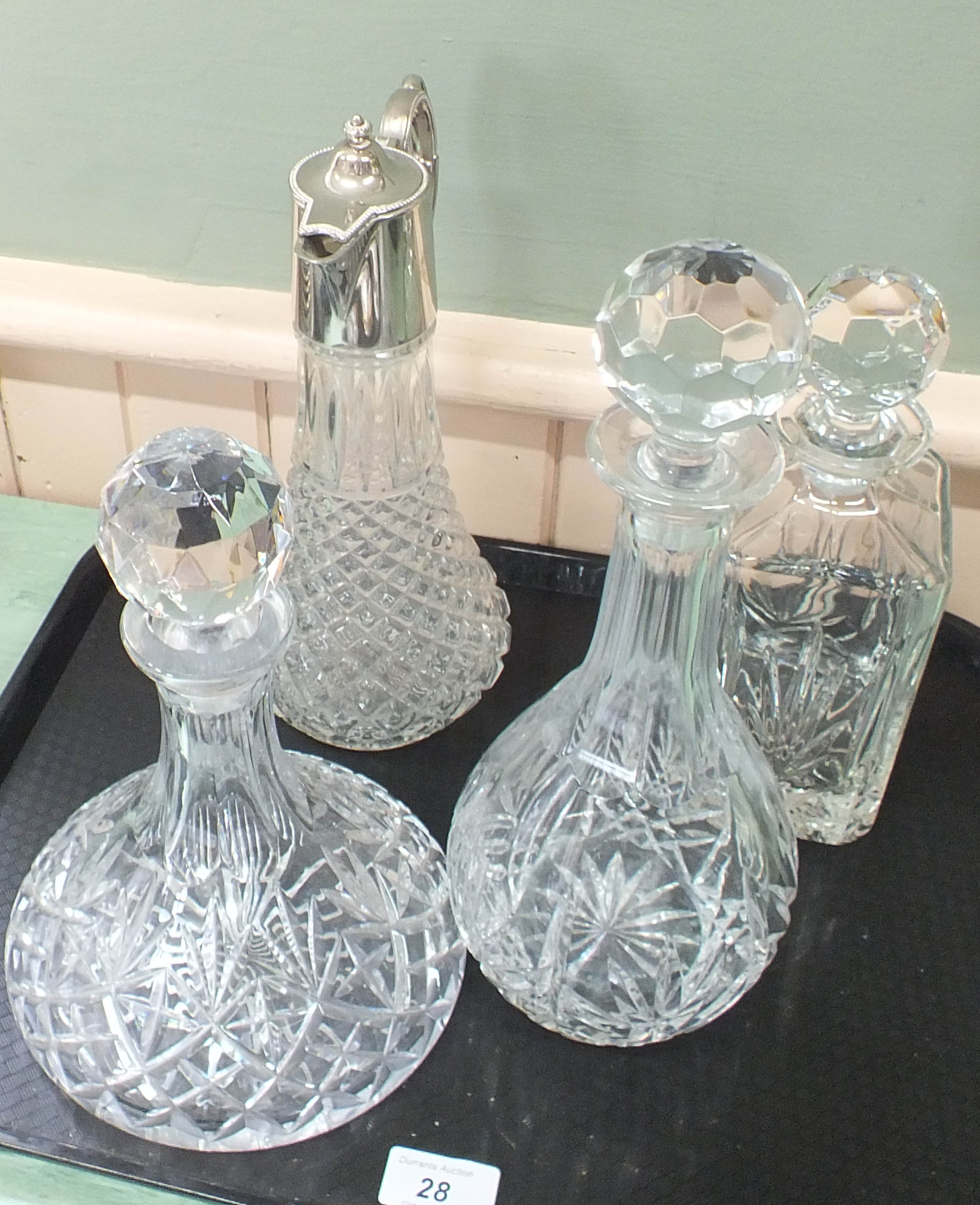 Three various cut glass decanters with a silver plate claret jug