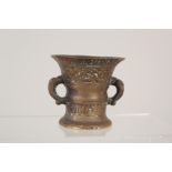 A small antique bronze mortar with band of text to the rim dated 1638 above two circles of