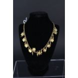 An unmarked yellow metal choker necklace made up of interlocking bead necklace set with multiple