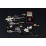 A selection of silver cutlery including preserve spoons (some as found), a silver 40g bar,