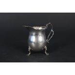 A silver cream jug on three paw feet, Birmingham 1920 by Ernest W.