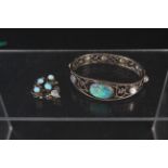 A white metal pierced design bangle set with large centre opal stone and cabochon moonstones plus
