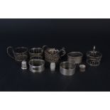 Three silver napkin rings, four silver cup holders (no glass) plus two silver thimbles,