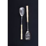 A pair of Victorian silver salad servers with engraved floral decoration, ivory handles (cracked),