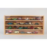 A wood and glazed display case with twenty four mixed age Matchbox Lesney etc die cast cars