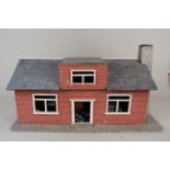 A vintage childs dolls house with furniture and dolls