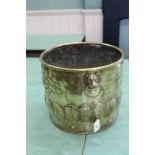 A decorative 19th Century embossed brass jardiniere or log bucket with lion mask ring handles,