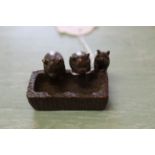 A small bronze of three pigs at a trough,