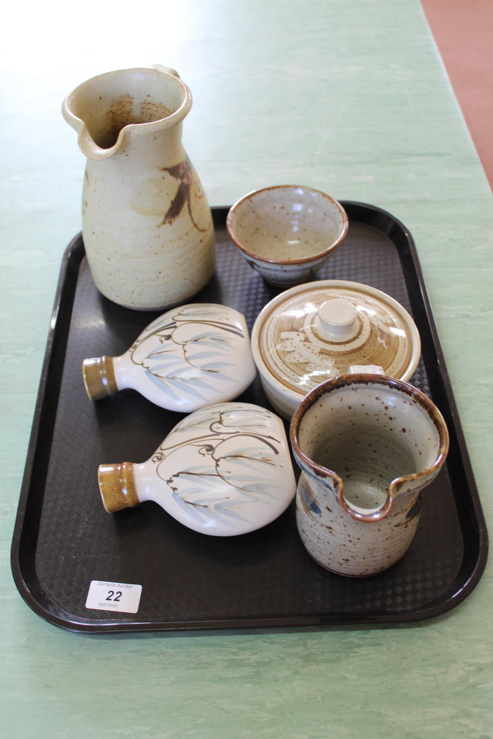 A pair of Studio Pottery moon flasks in an off white ground with pale blue leaf decoration,